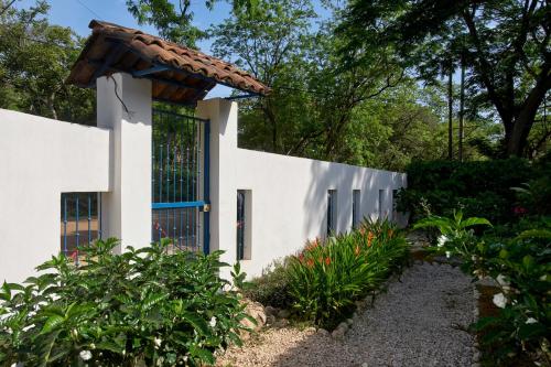 a white house with a blue door at Tamarindo Blue Apartments in Tamarindo