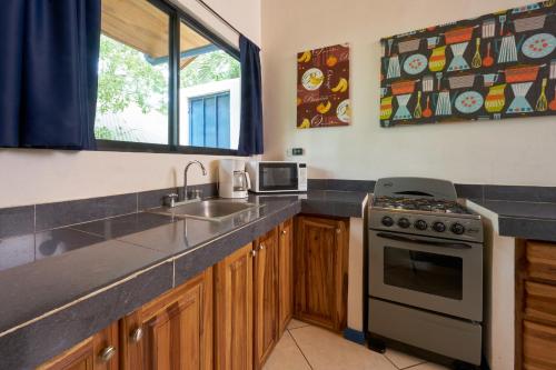 a kitchen with a sink and a stove at Tamarindo Blue Apartments in Tamarindo