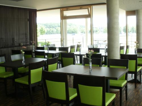 un comedor con mesas y sillas verdes en iQ-Hotel Ulm en Ulm