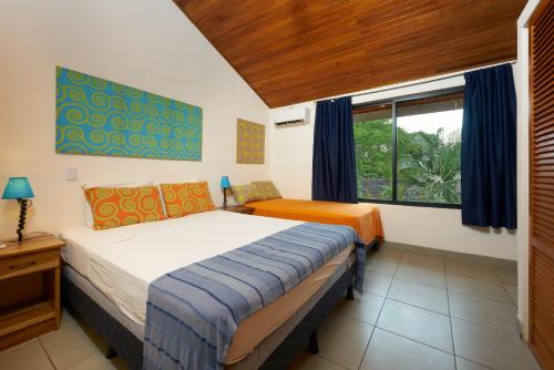 Säng eller sängar i ett rum på Tamarindo Blue Apartments