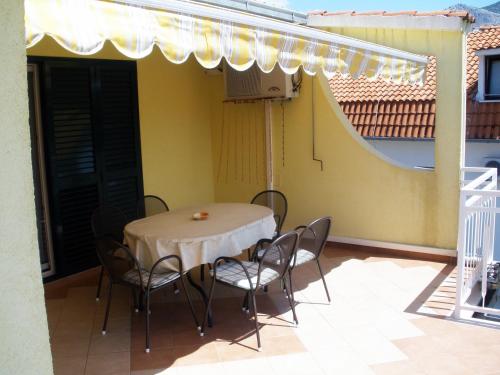 a table and chairs on the balcony of a house at Maglić Apartment in Duće