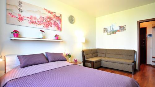 1 dormitorio con cama morada y sofá en Apartment Evia, en San Petersburgo