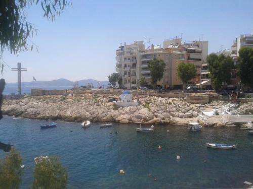 a group of boats in a body of water with buildings at Super 36sqm Junior Suite in luxurious picturesque area in Piraeus