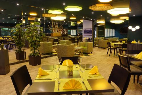 un restaurante con mesas y sillas con servilletas amarillas en Trans World Hotel Auefeld, en Hannoversch Münden