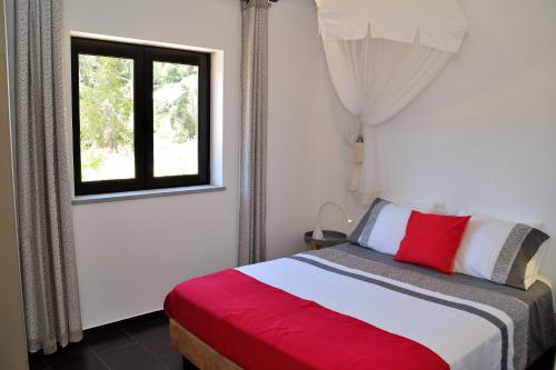 een slaapkamer met een bed en een raam bij Pirilampo in Monchique