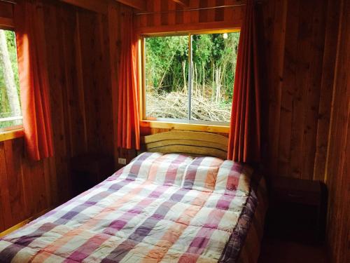niewielka sypialnia z łóżkiem i oknem w obiekcie Cabana en Las Cascadas w mieście Puerto Clocker