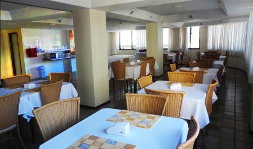 a dining room with tables and chairs in a restaurant at Hotel Monte Carlo Uberaba - Próximo ao Hospital UFTM , Hospital Dr Hélio Angotti e Hospital Regional Uberaba in Uberaba