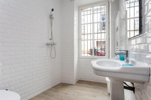 une salle de bain blanche avec un lavabo et une douche dans l'établissement Le Petit Nicolas, à Montpellier