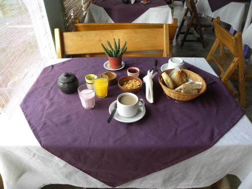 a purple table with a breakfast of coffee and bread at Descanso de las Piedras in Tafí del Valle