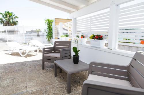 a patio with chairs and tables and windows at Innsud in Nardò