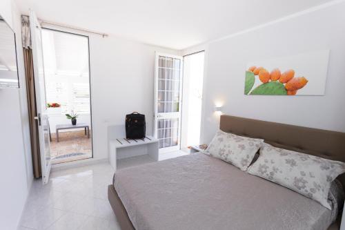 a white bedroom with a bed and a window at Innsud in Nardò