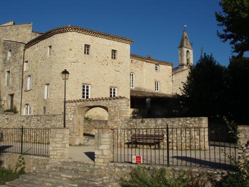 a building with a gate and a bench in front of it at La Bastide Cévenole in Rochegude-Gard