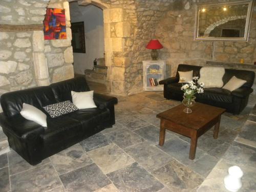 a living room with two black couches and a table at La Bastide Cévenole in Rochegude-Gard