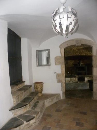 a living room with a stone fireplace and a chandelier at La Bastide Cévenole in Rochegude-Gard