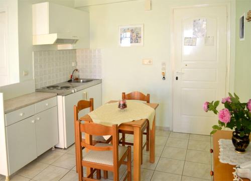 a kitchen with a table and chairs in a kitchen at Athos Studios in Tinos Town