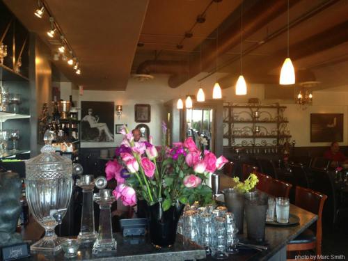 a table in a restaurant with pink flowers on it at Harrison Beach Hotel in Harrison Hot Springs