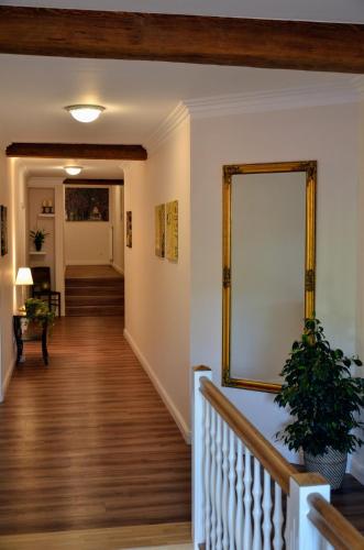 a hallway of a home with a mirror and stairs at Pension am Birkensee in Detern