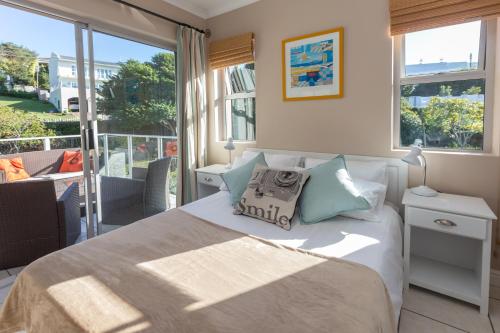 1 dormitorio con 1 cama y balcón en Plett's Life, en Plettenberg Bay