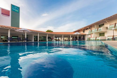 a swimming pool in front of a hotel at Arrey Hotel Beach in Parnaíba