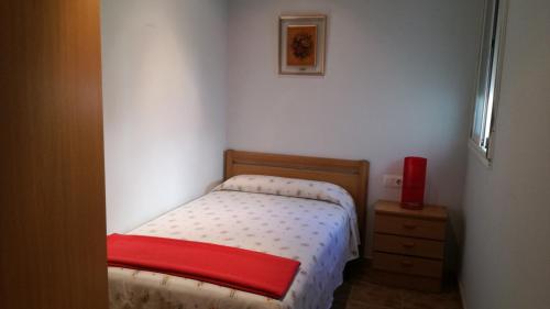 een kleine slaapkamer met een klein bed en een dressoir bij Casa Paxixa in Sant Jaume d'Enveja