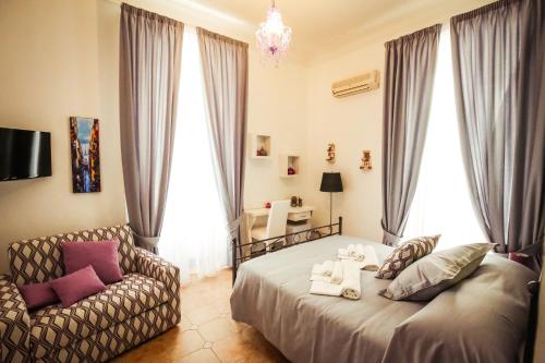 a bedroom with a bed and a couch at NapoliMia Boutique Hotel in Naples