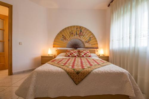 a bedroom with a large bed with a wooden headboard at Calafell Apartment 2 in Calafell