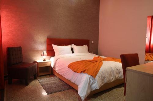 ein Schlafzimmer mit einem Bett mit einer orangefarbenen Decke in der Unterkunft Point du Jour in Casablanca