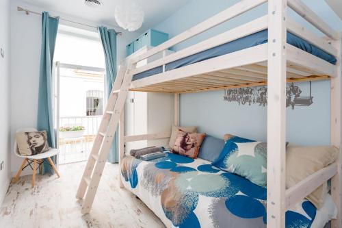 een slaapkamer met een stapelbed en een ladder bij La Perla de La Caleta in Cádiz