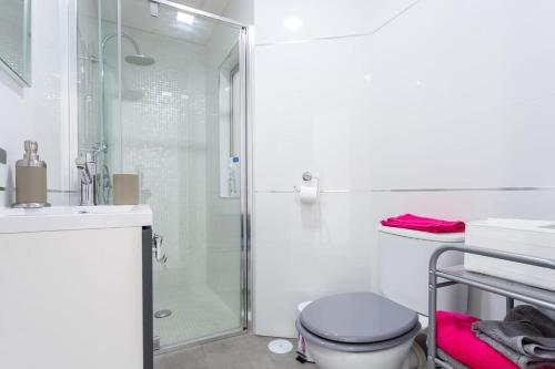 een badkamer met een douche, een toilet en een wastafel bij La Perla de La Caleta in Cádiz