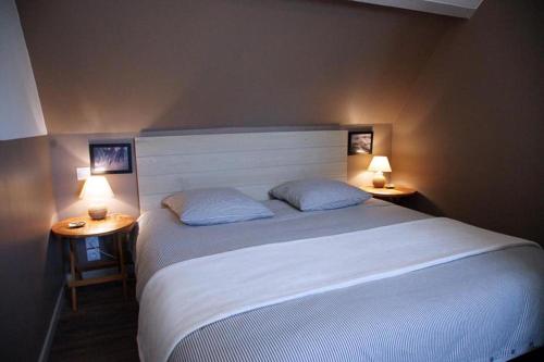 La Dunette في بينمارش: غرفة نوم بسرير كبير مع وجود مصباحين على الطاولات