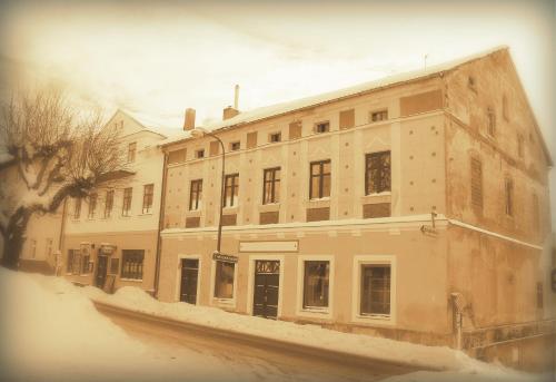 an old building on a street with snow on the ground at Apartmány16 Olešnice v Orlických horách in Olešnice v Orlických horách