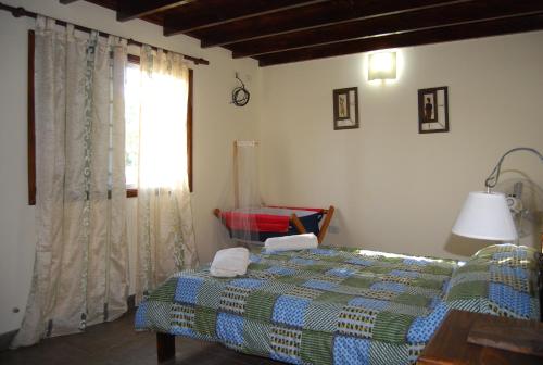 a bedroom with a bed and a window at La Posada de Damian in San Clemente del Tuyú