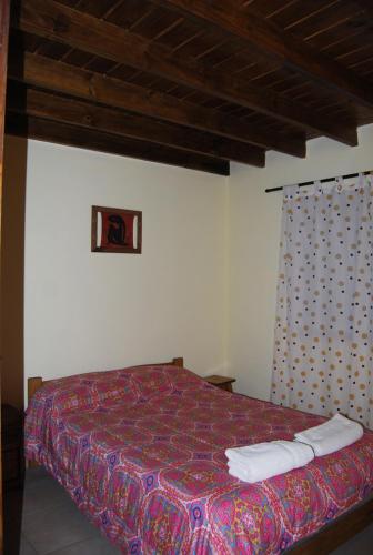 a bedroom with a bed with a colorful bedspread at La Posada de Damian in San Clemente del Tuyú
