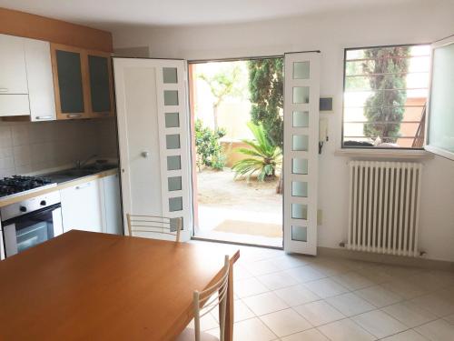 a kitchen with a table and a door to a yard at Miramare Beach Apartment in Rimini