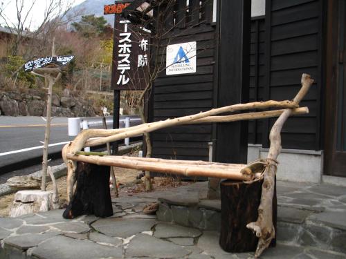 a wooden bench made out of tree logs at Yufuin Country Road Youth Hostel in Yufuin