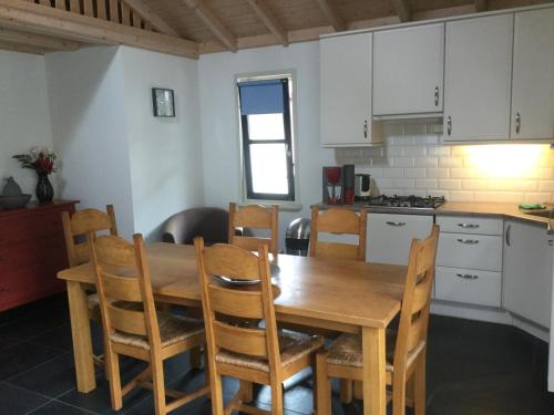 a kitchen with a wooden dining room table and chairs at Vakantiepark Krabbenkreek in Sint Annaland