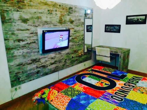 a bed in a room with a tv on a wall at Vip apartment Beograd in Belgrade