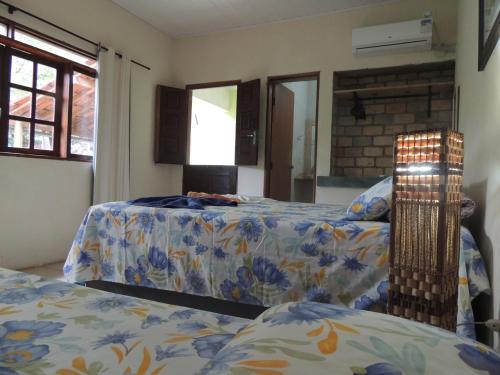 a bedroom with two beds and a window at Canto Verde Pousada in Lençóis