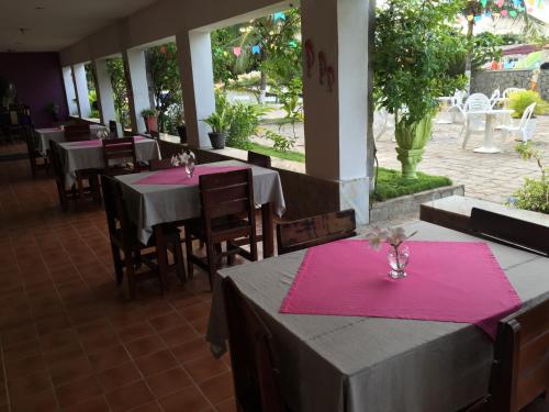 a restaurant with tables and chairs with pink napkins at Beach Hotel Jacuma in Jacumã