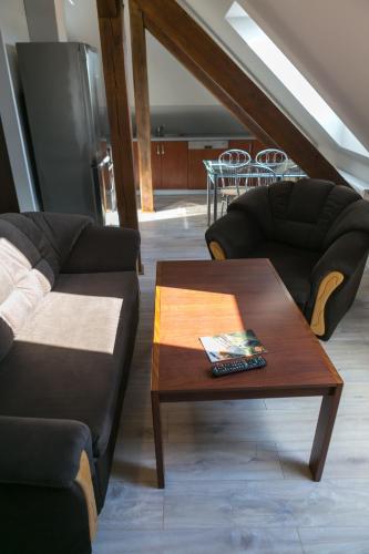 a living room with two couches and a coffee table at Mazurskie Apartamenty in Pasym