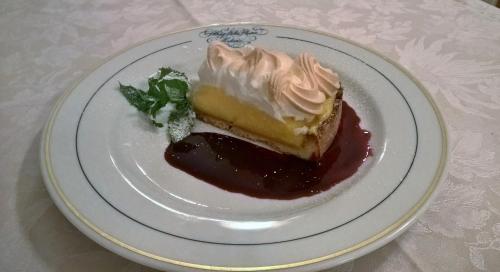a piece of cake on a plate on a table at Albergo Stella Alpina in Molveno