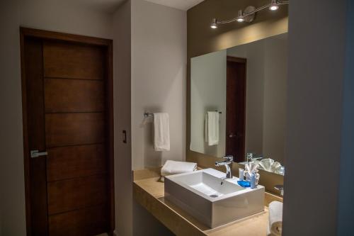 a bathroom with a sink and a large mirror at Ocean View Beach Hotel in Mazatlán