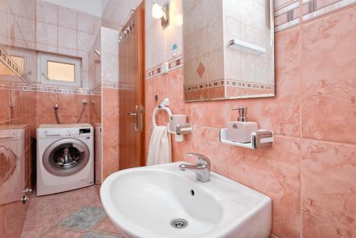 a bathroom with a sink and a washing machine at Villa Vista in Jelsa