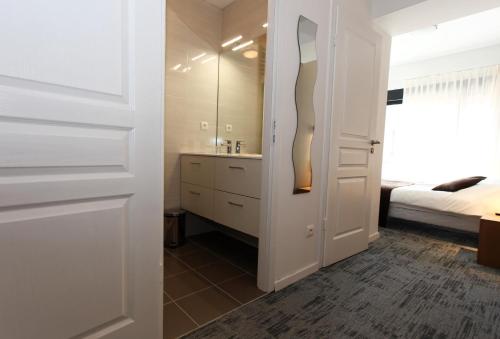 a bathroom with a sink and a bed in a room at Hôtel De L'Ill in Strasbourg