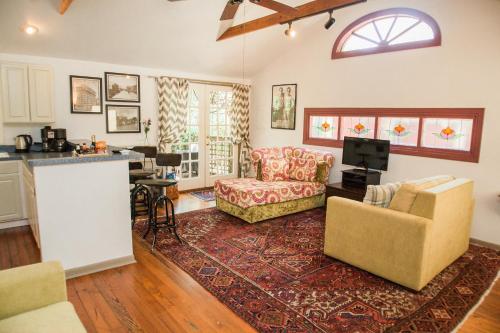 a living room with a couch and chairs and a kitchen at Park Lane Guest House in Austin