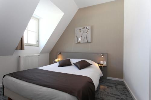 a bedroom with a large bed in a attic at Hôtel De L'Ill in Strasbourg
