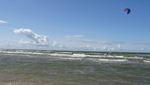 a person kite surfing in the ocean on the beach at Sea House Dzelmes in Mazirbe
