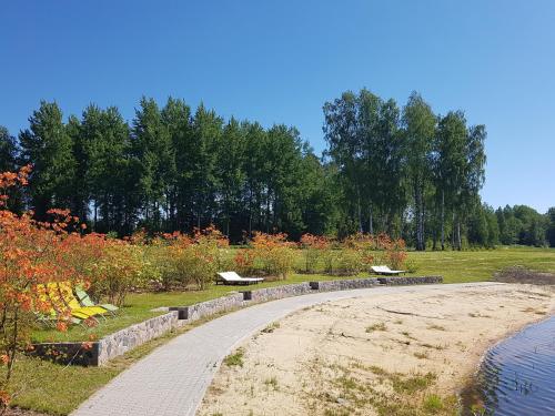 a walkway in a park with benches and flowers at Meždzirnas Country House & SPA in Kabile