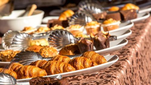 a buffet line with plates of pastries and desserts at Hotel Aurora in Lido di Jesolo