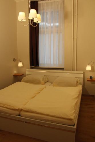 a bedroom with a white bed with a window at Stars Berlin Apartments Zillestraße in Berlin